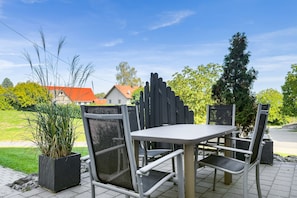 An outdoor seating area with a table and chairs, surrounded by potted plants and a view of a residential area. - Vacation apartment Dandelion, 83sqm, 2 bedrooms, max. 4 persons (Ravensburg)