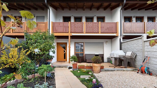 Ein zweistöckiges Gebäude mit Balkon, Außenbereich und Garten.