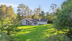 A single-story house with a covered patio and a lawn.