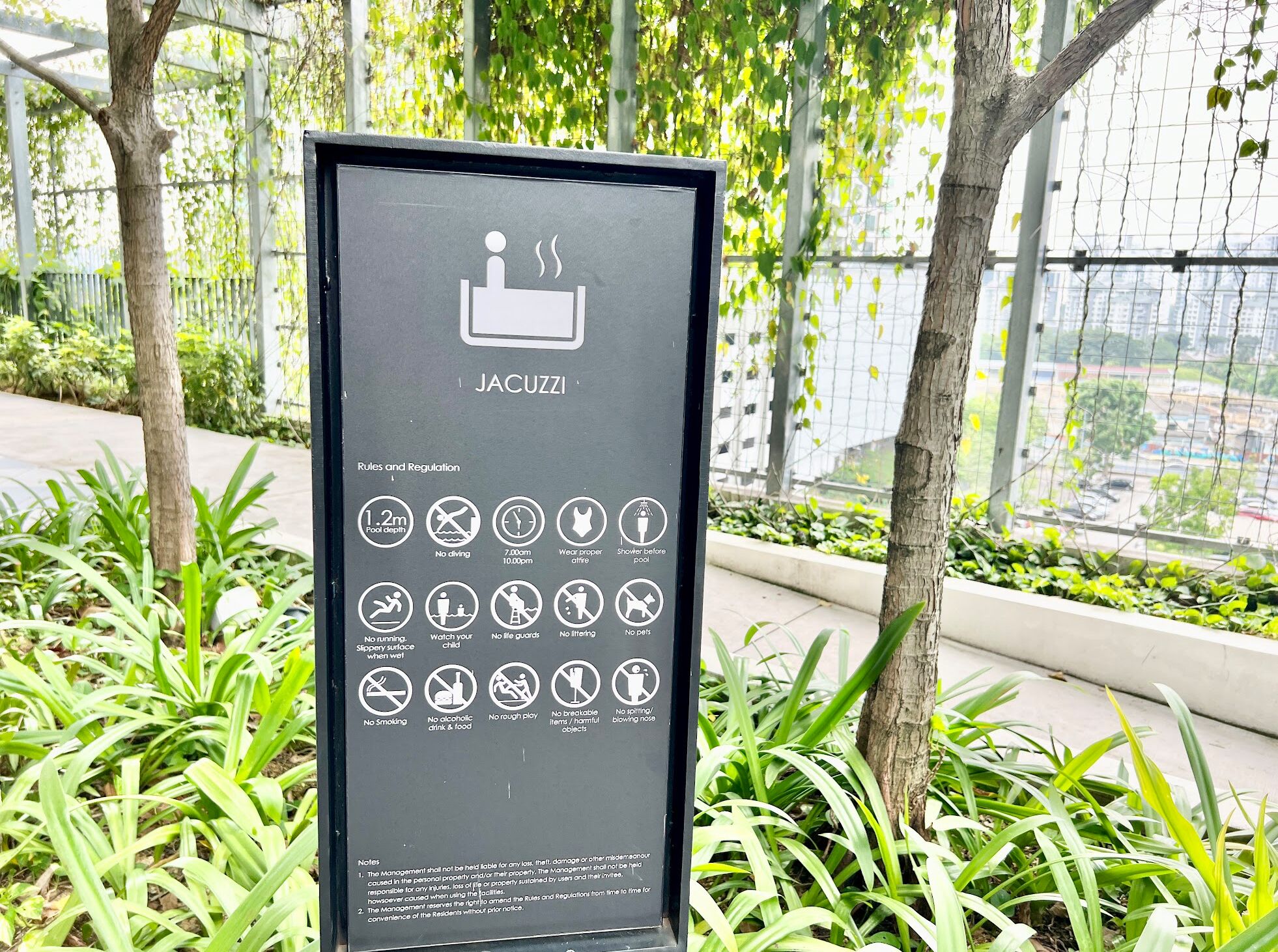 A signboard with rules and regulations for a jacuzzi area, including depth limit, no diving, and no smoking.