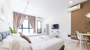 Una habitación de hotel moderna con una cama grande, un escritorio, un televisor de pantalla plana y una zona de comedor.