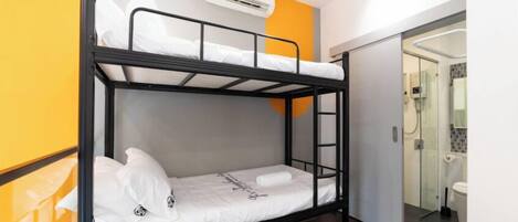 A bunk bed in a room with a glass shower door, a white air conditioning unit, and a yellow accent wall.