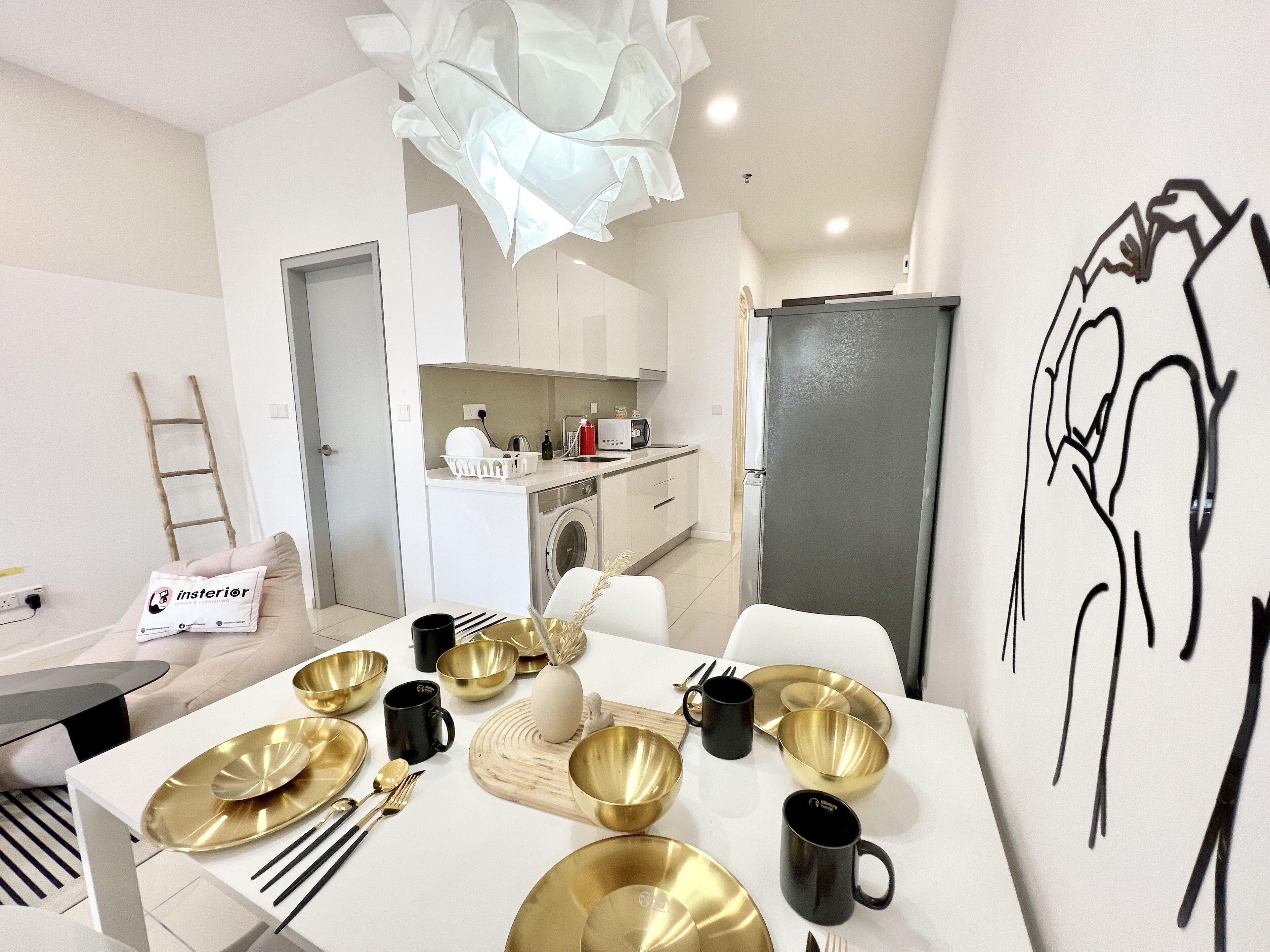 Une cuisine moderne avec des meubles blancs, un lave-linge et un réfrigérateur.