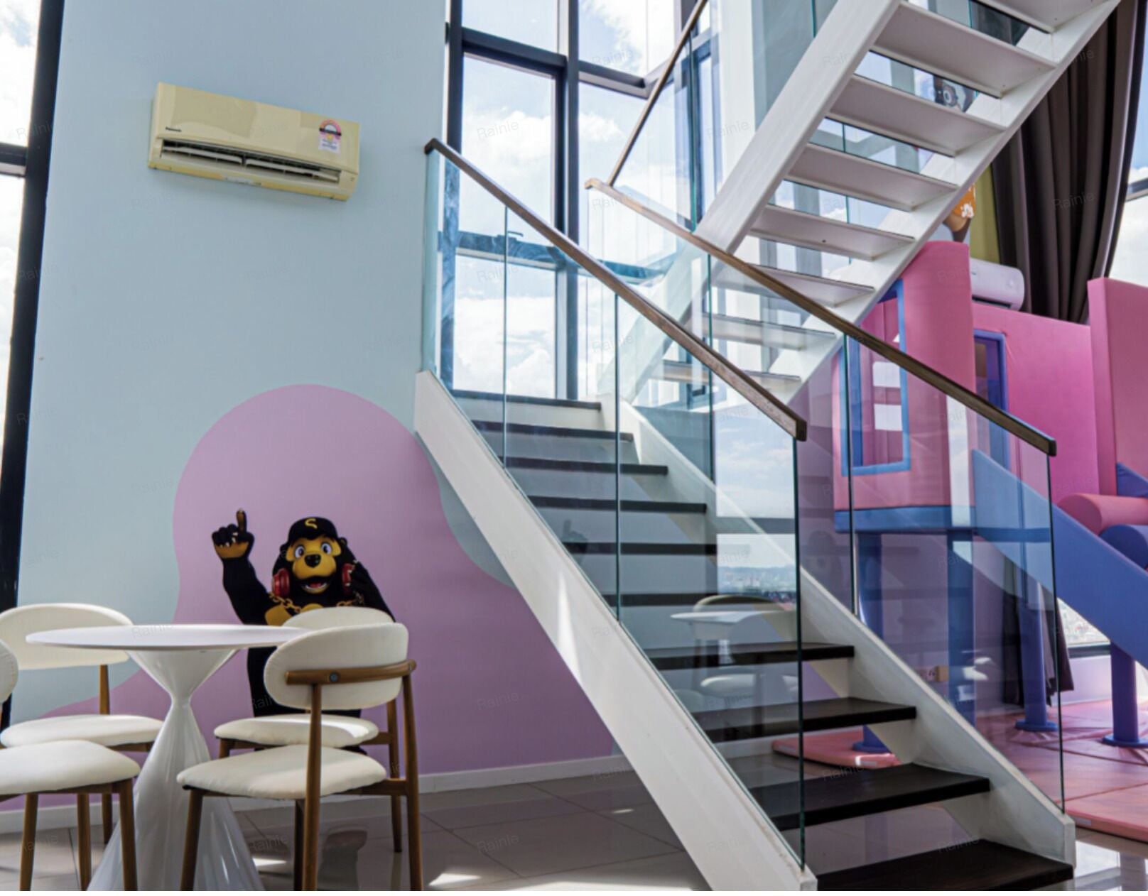 A modern interior with a staircase, a play area, and a table with chairs.