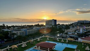 A resort with a pool, sunbathing areas, and a view of the sunset over the ocean. - refurbished holiday home very close to the beach (Solana Matorral)