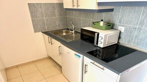A compact kitchen with a sink, a microwave, and a dishwasher. - refurbished holiday home very close to the beach (Solana Matorral)