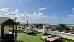 A rooftop terrace with a view of the beach, a small gazebo, and lounge chairs. - refurbished holiday home very close to the beach (Solana Matorral)