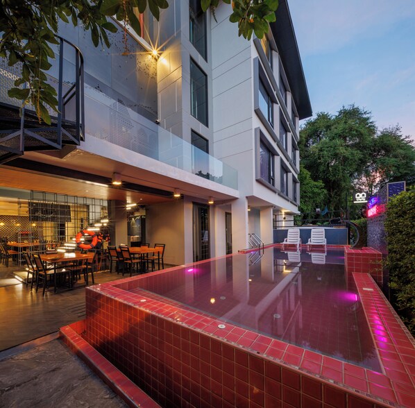 Un bâtiment moderne doté d’une piscine, d’un espace extérieur aménagé et d’un restaurant.