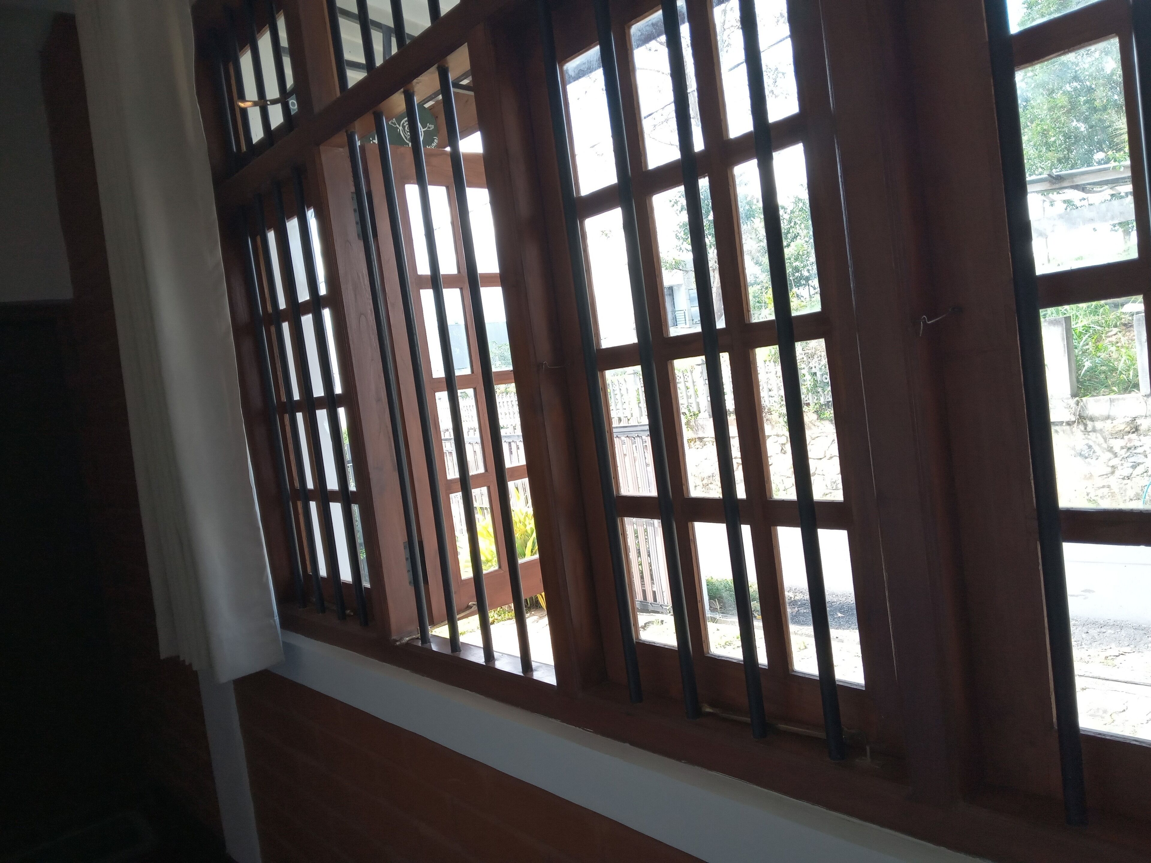 A room with wooden-framed windows and a white baseboard.