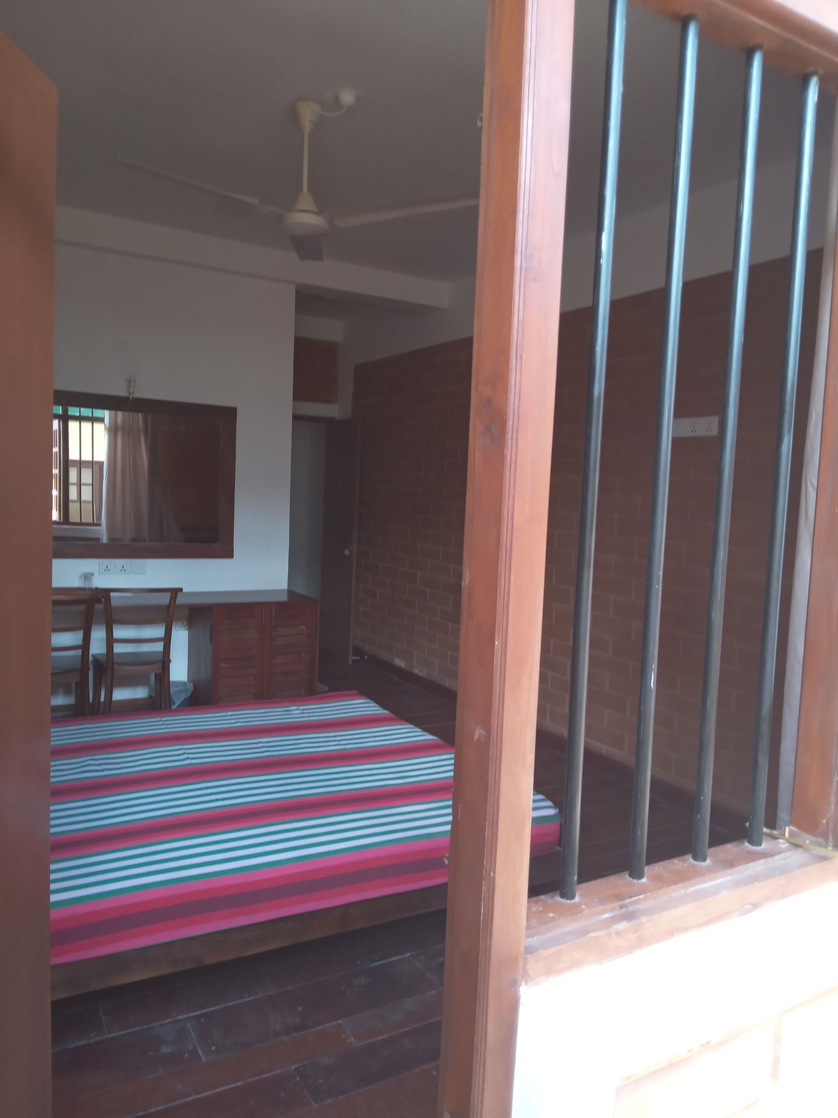 A room with a bed, a desk, and a window.