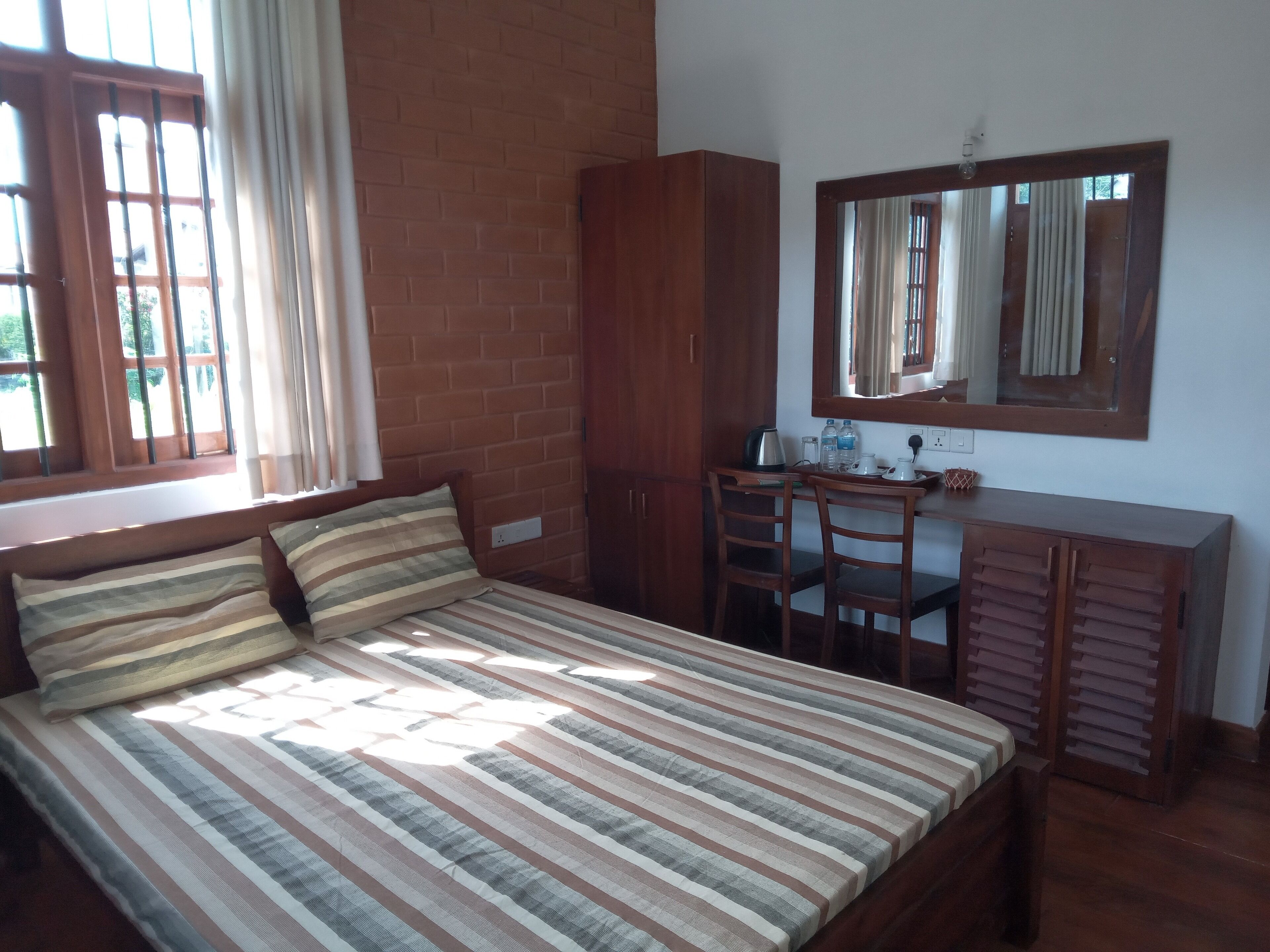 A bedroom with a bed, a desk, and a wardrobe.