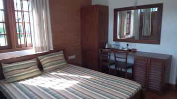 A bedroom with a bed, a desk, and a wardrobe.