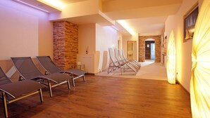 A spa area with wooden flooring, stone walls, and multiple sun loungers. - Beautiful group accommodation with sauna & ski-in (Itter)