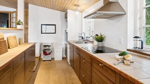 A modern kitchen with wooden cabinets, a stainless steel sink, and a window providing natural light.