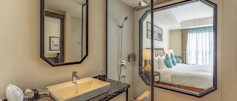 A modern bathroom with a large mirror, a sink, and a shower.