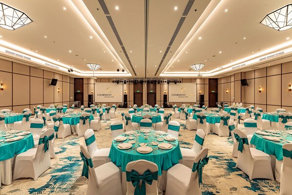 A large banquet hall with round tables, white chairs, and teal tablecloths. - Charmant Suites a Boutique Hotel Can Tho (Can Tho)
