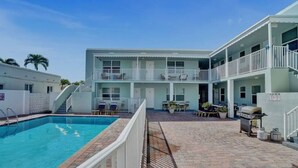 A hotel with a swimming pool, outdoor seating, and a barbecue area. - The Cozy Pelican Studio! Just Steps to the Sand! (Hollywood)