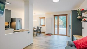 Un appartement moderne doté d’une cuisine, d’un coin repas et d’un balcon.