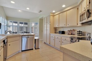 A modern kitchen with white cabinets, stainless steel appliances, and a dishwasher.