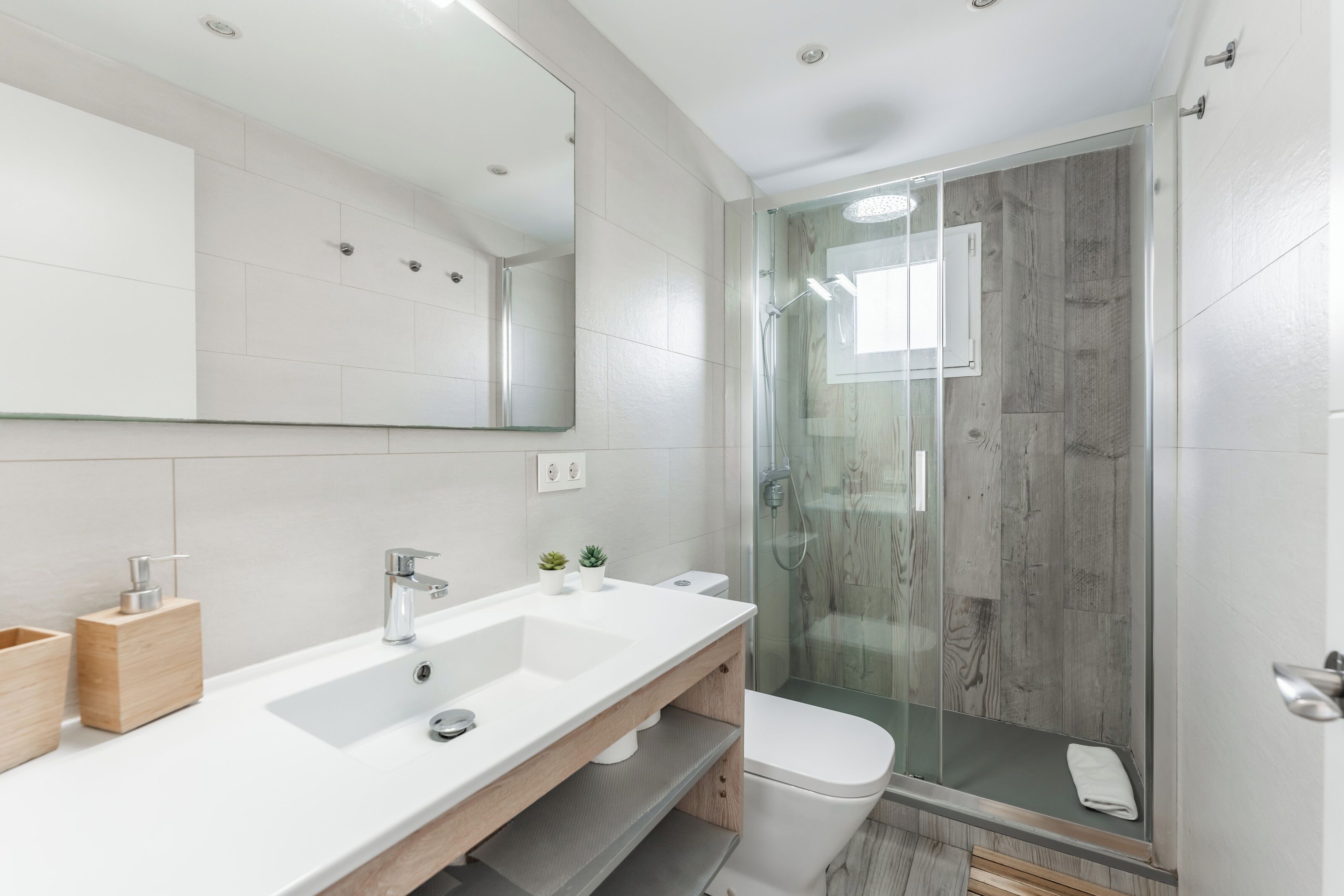 Familie appartement | Badkamer | Een douche, een regendouche, een haardroger, handdoeken