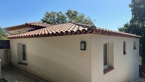 A small, single-story building with a tiled roof, a door, and a window.