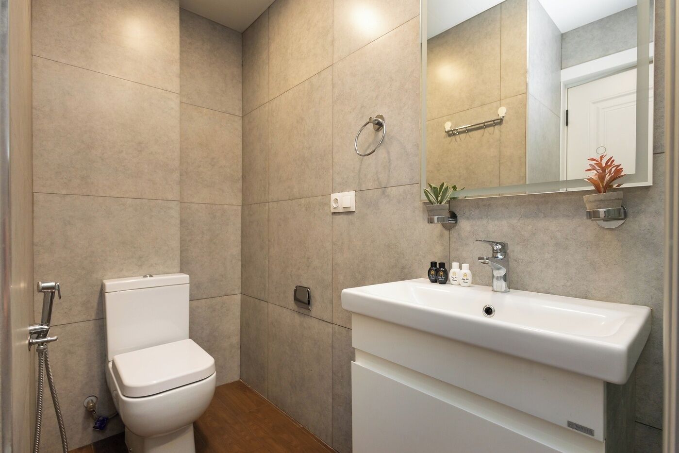 A modern bathroom with a toilet, sink, and shower.