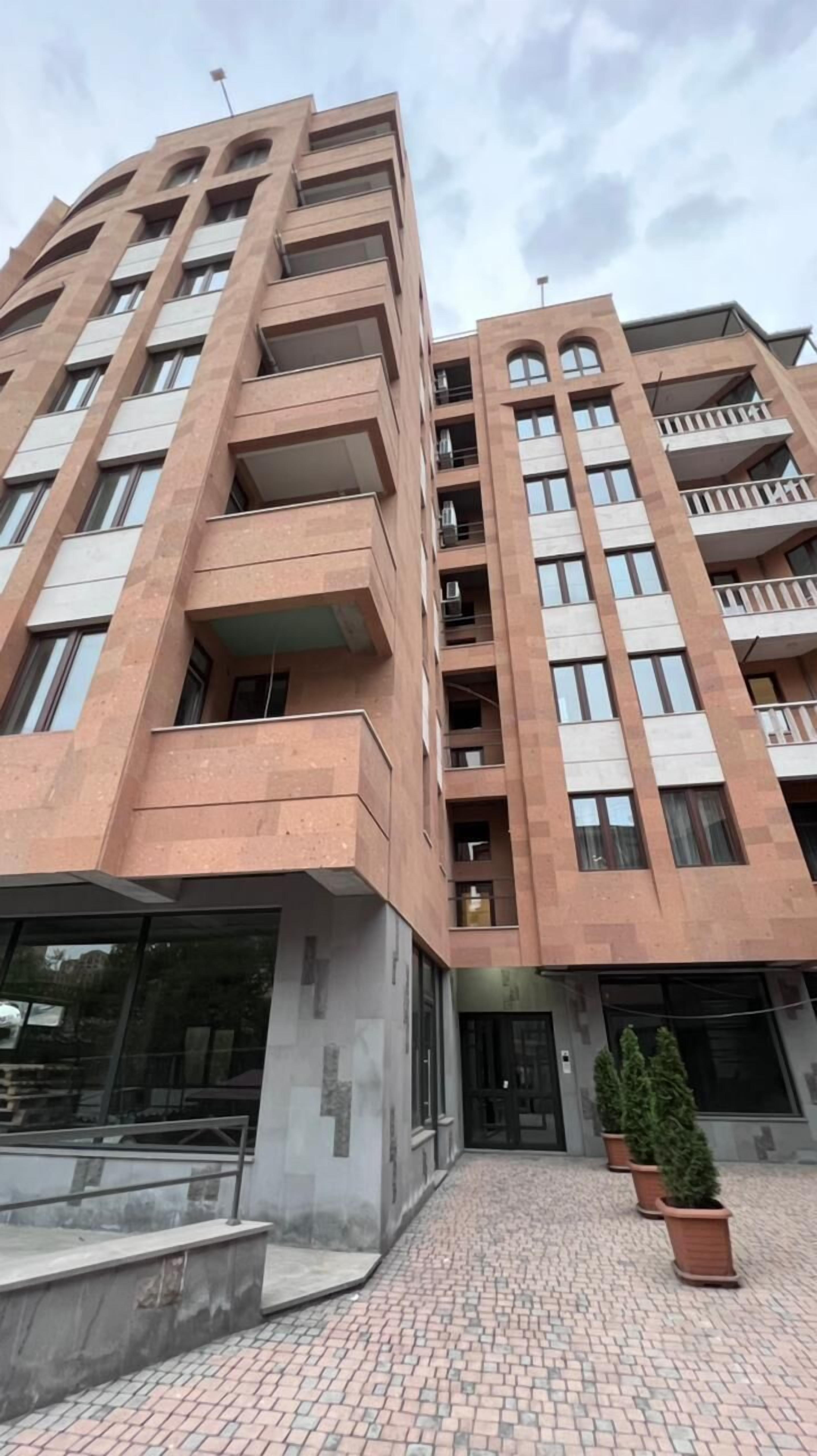 A multi-story building with a modern architectural design, featuring balconies and large windows.