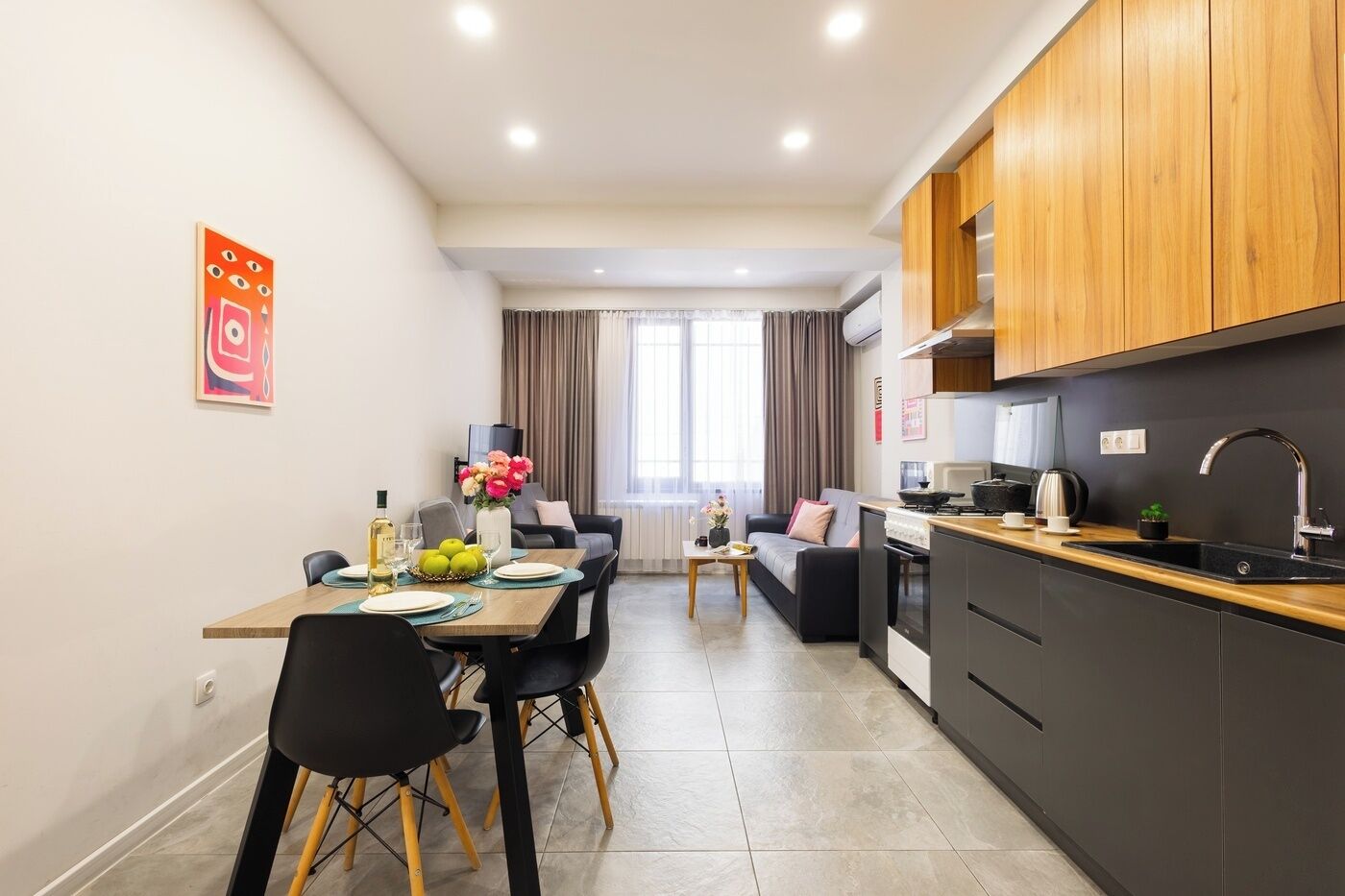 A modern apartment with a dining area, kitchen, and living space.