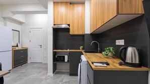 Une cuisine moderne avec des meubles en bois, un four encastré et une machine à café posée sur le plan de travail.