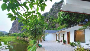 A pathway leading to a building with a view of a lake and a mountain. - Vivian riverside cottage - Ninh Bình (Ninh Binh)