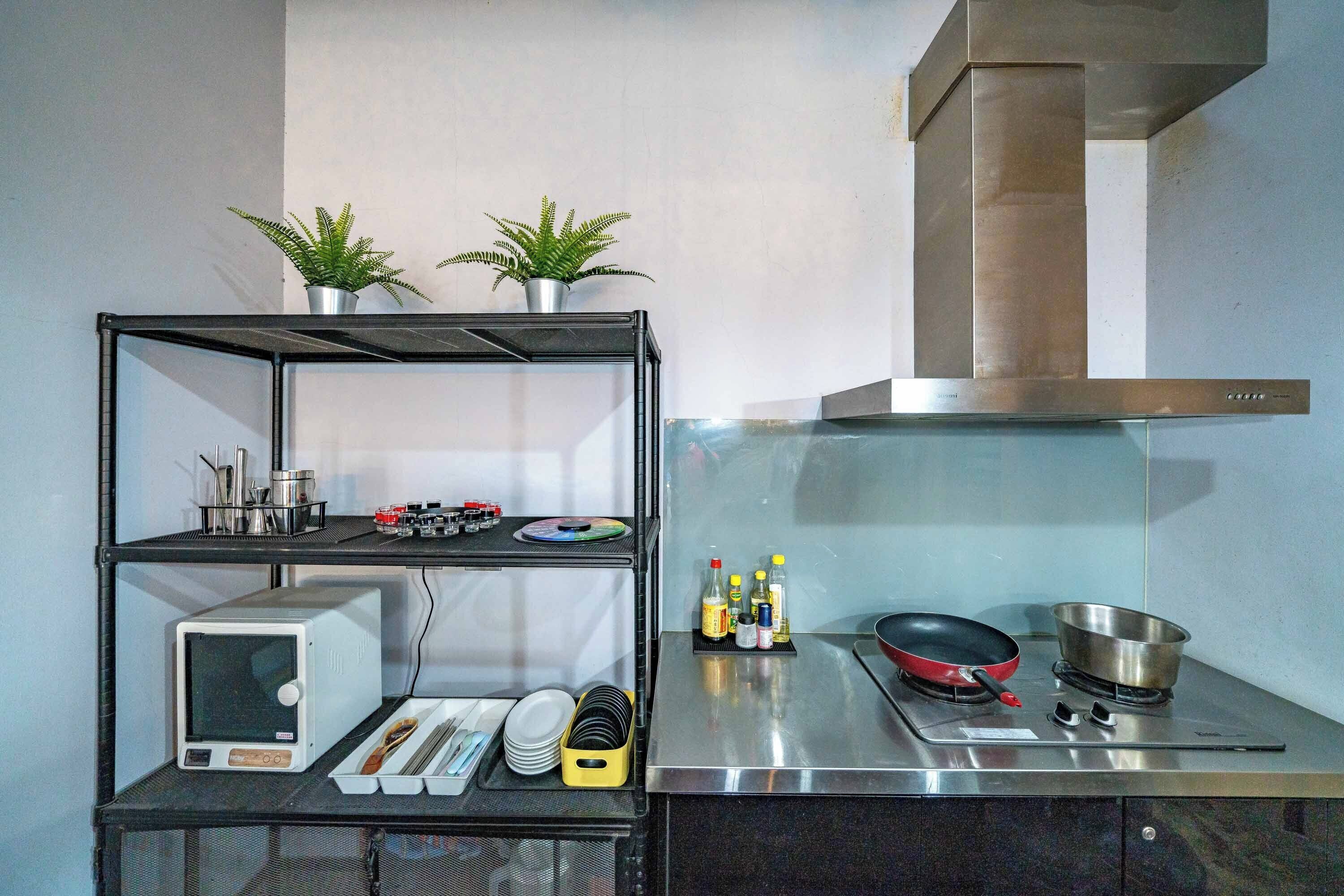 A compact kitchen with a microwave, stove, and various utensils.