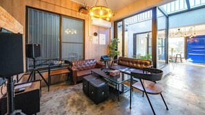 A modern living room with leather sofas, a glass coffee table, and a large window. - B&B near the seaside (Ji'an)