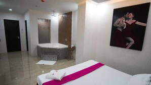 A hotel room with a large bed, a bathtub, and a painting on the wall. - OYO 1030 AI Hotel (Caloocan)