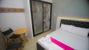 A hotel room with a bed, a small round table, and two folding chairs. - OYO 1030 AI Hotel (Caloocan)