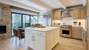 Una cucina moderna con una grande isola, elettrodomestici in acciaio inossidabile e mobili in legno.