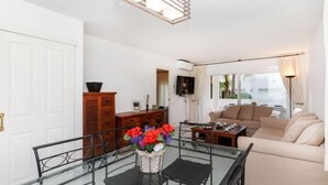 A modern living room with a glass dining table, a sofa, and a TV. - Nautic Par by Interhome (Playa de Aro)