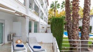 A modern building with a balcony featuring two lounge chairs with cushions. - Nautic Par by Interhome (Playa de Aro)