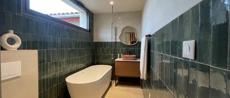 A modern bathroom with a freestanding bathtub, a toilet, and a sink.