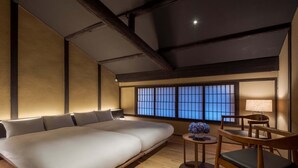 Une chambre moderne avec un grand lit, une petite table avec une lampe et une chaise.