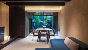 Un intérieur moderne comprenant un coin repas, un canapé et une vue sur la verdure environnante.