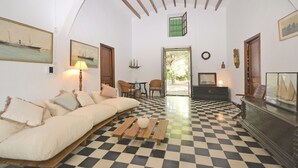 A room with a checkered floor, a sofa, a lamp, and a wooden cabinet. - Teresa - beautiful house 150 meters from the beach (Alcúdia)