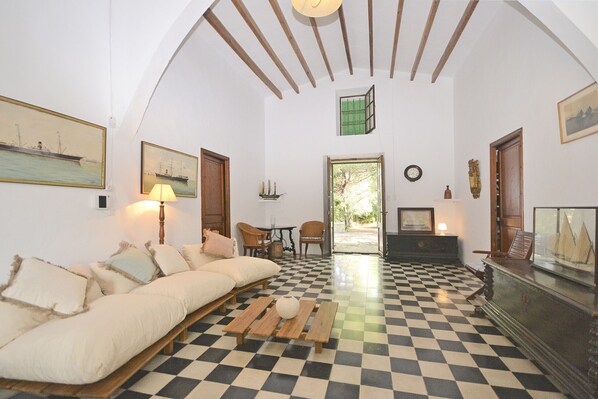 A room with a checkered floor, a sofa, a lamp, and a wooden cabinet.