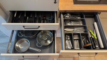 A kitchen drawer with utensils and cookware.