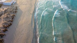 An aerial view of a beach with a building and a fenced area. - Corte Largo Lauro Dimore&Spa (Ugento)