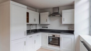 A modern kitchen with white cabinetry, a stainless steel sink, and a Bosch oven. - Farringdon 1-Bed Apartment · Lift · Sleeps 3 (London)