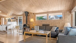 A cozy cabin interior with a wooden ceiling, a sofa, a dining table, and a kitchen area. - "Thrineke" - 600m from the sea by Interhome (Saltum)