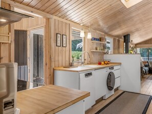 Une cuisine moderne avec des meubles en bois, un lave-vaisselle encastré et un évier.