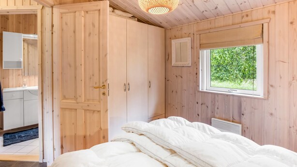 A wooden room with a bed, a window, and a door. - "Thrineke" - 600m from the sea by Interhome (Saltum)