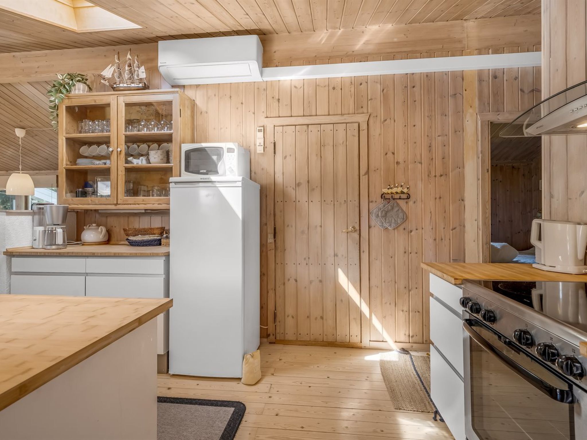 Une cuisine avec des meubles en bois, un four à micro-ondes, un réfrigérateur et une cuisinière.
