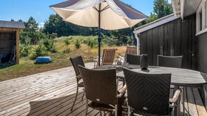 A wooden deck with outdoor furniture and a large umbrella. - "Thrineke" - 600m from the sea by Interhome (Saltum)